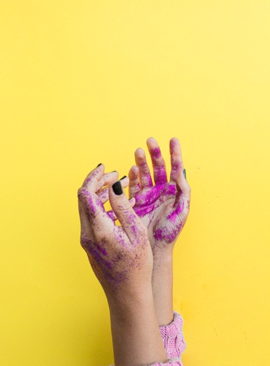 Two hands with purple paint on them.