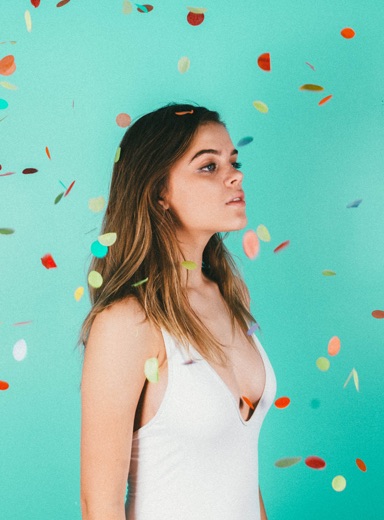 A woman with confetti flowing around her.